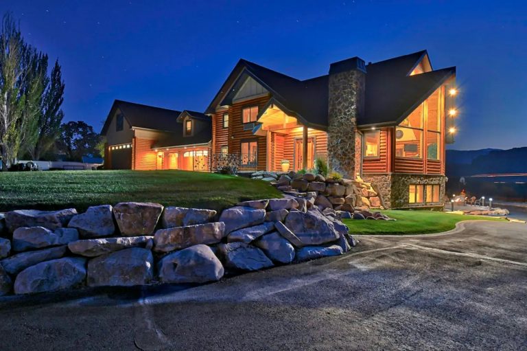 Luxury mountain home with stone and timber exterior at dusk