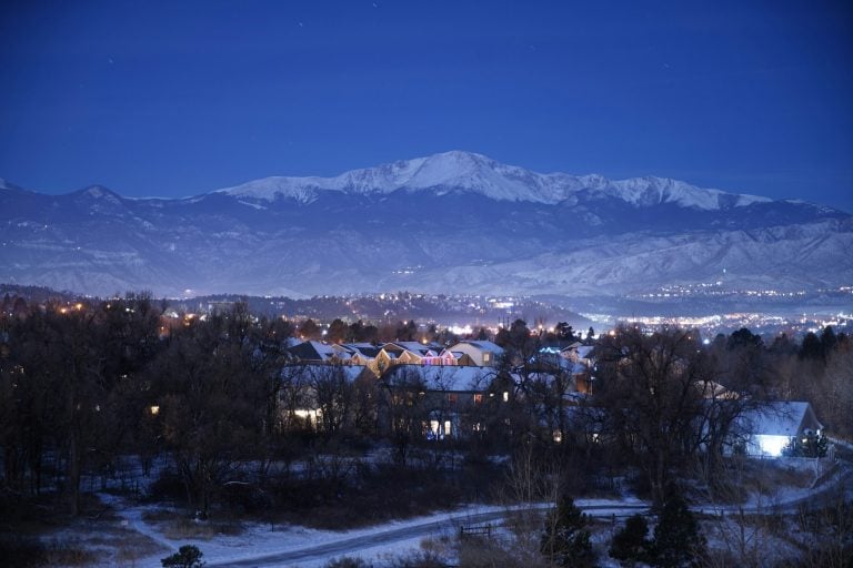 Homes below a snow-covered Colorado peak